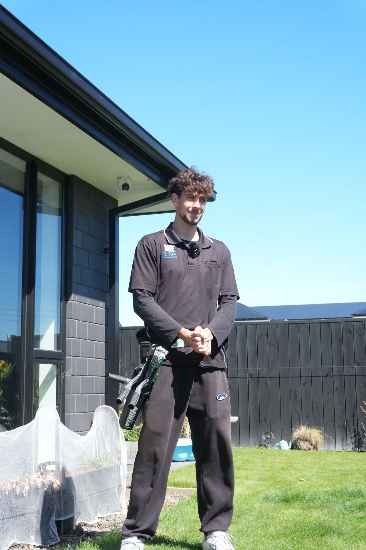 A friendly Never Dirty Again team member in uniform outside a Christchurch home