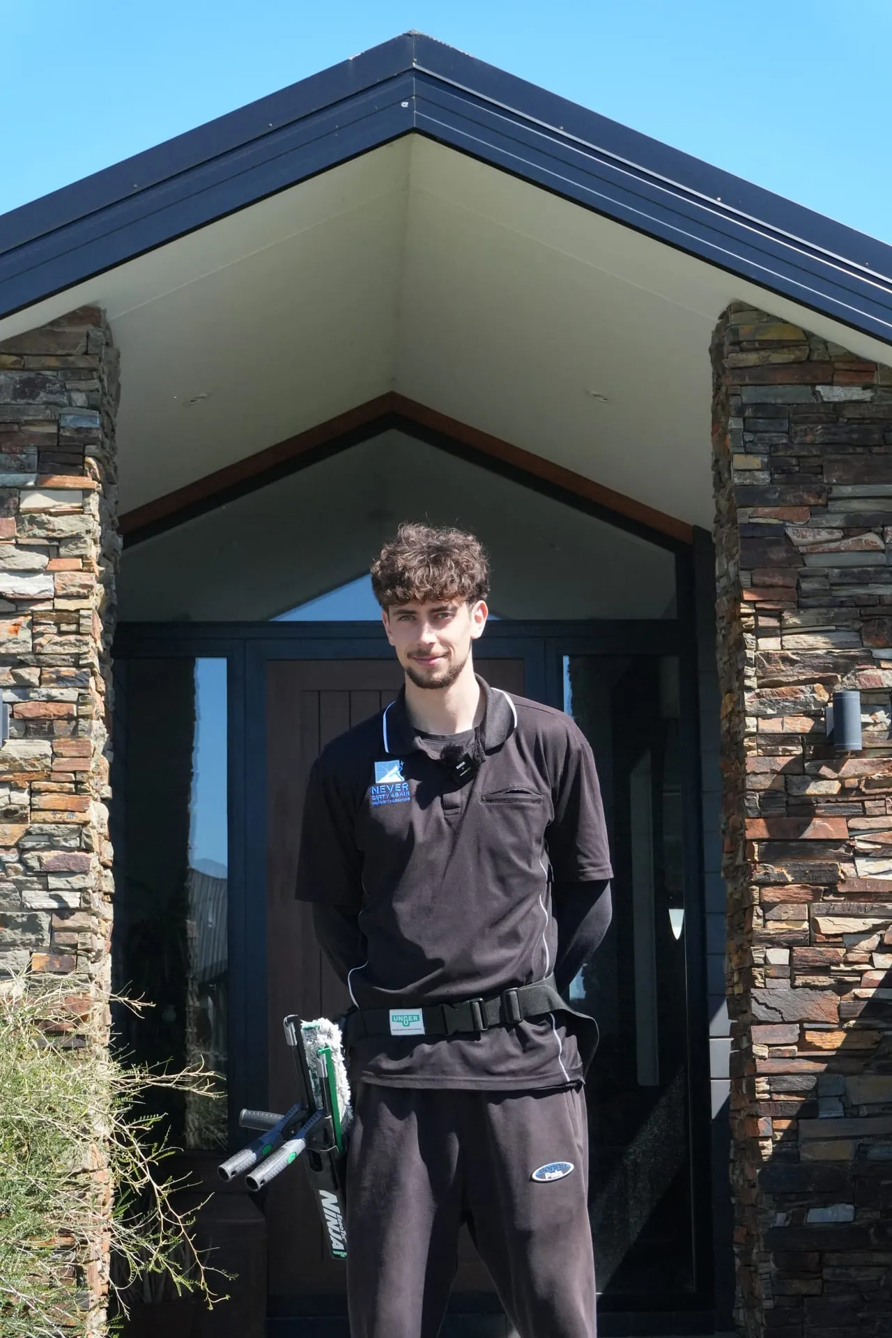 A friendly Never Dirty Again team member in uniform outside a Christchurch home